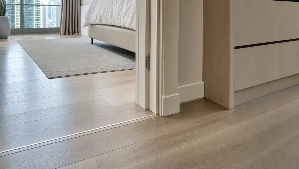 A finished doorway threshold in a Dubai home shows aligned flooring and clean trim where the original room meets the new addition.